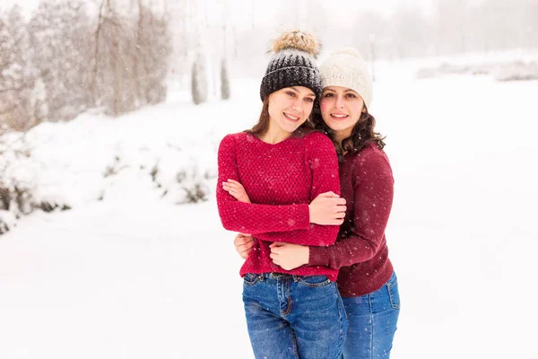 Двоє GIRLS IN RED SWEATERS In the WINTER FOREST — стокове фото