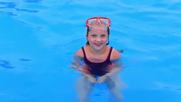 Dítě v plavkách a vodní masce plave v bazénu v aquaparku. — Stock video