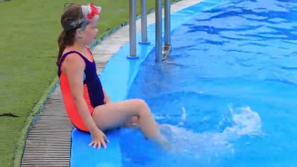 Ein Kind in Badeanzug und Wassermaske schwimmt im Pool des Wasserparks. — Stockvideo