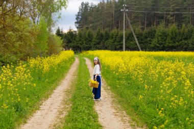 Çiçek açan bir tarlada sarı çiçekli bir çocuk.
