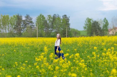 Çiçek açan bir tarlada sarı çiçekli bir çocuk.