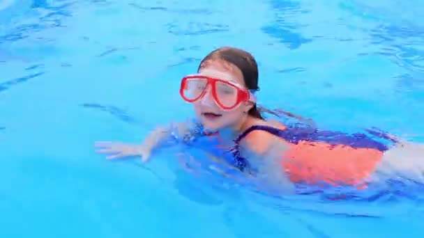 Dítě v plavkách a vodní masce plave v bazénu v aquaparku. — Stock video