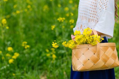 Çiçek açan bir tarlada sarı çiçekli bir çocuk.