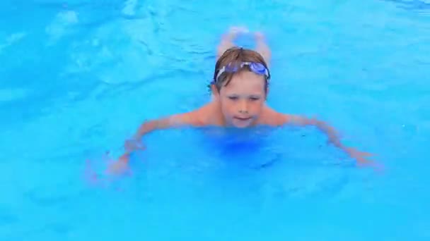 Mayolu ve su maskeli bir çocuk su parkının havuzunda yüzer.. — Stok video