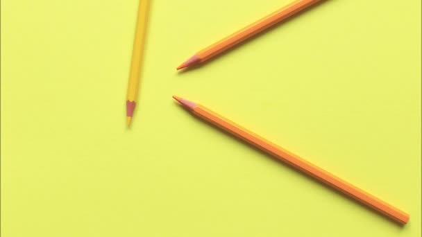 Sarı arka planda renkli kalemlerin hareketi. — Stok video