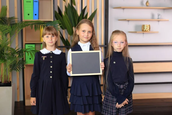 Três meninas estão segurando um quadro de desenho em uma moldura. — Fotografia de Stock