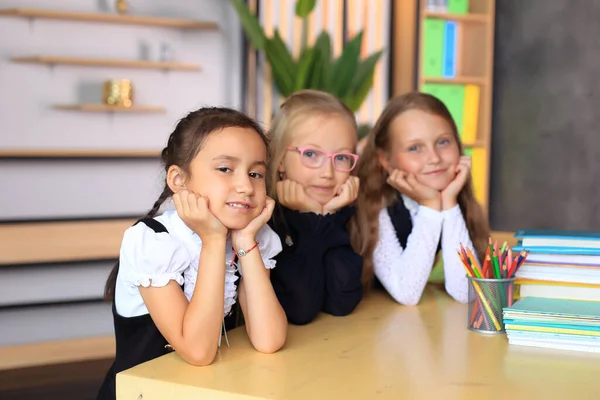 Junge Studentinnen in Schuluniformen vor dem Unterricht im Klassenzimmer. — Stockfoto