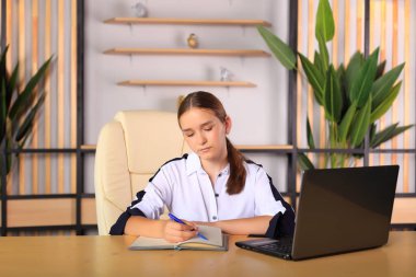 Ofisteki bilgisayarın başında genç bir kız oturuyor..