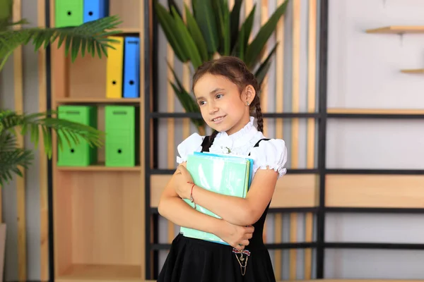 Jong schoolmeisje in de klas in een schooluniform — Stockfoto