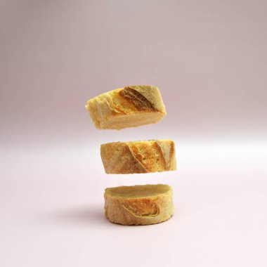 Pastel arka planda ekmek dilimleri var. Temiz modern tarzı, hafifliği ve şiirselliği olan en az gıda sanatı konsepti.