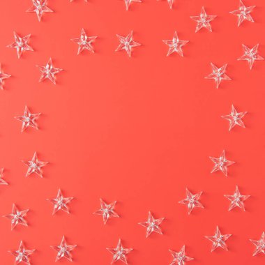 Kırmızı mercan yüzeyinde saydam yıldızların olduğu minimum Noel arkaplanı. Yaratıcı şenlik düzlüğü