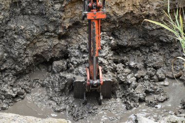 Yeni bir su birikintisi için kazı çalışmaları ile mini ekskavatör