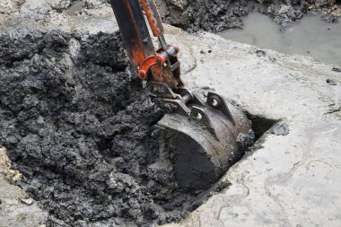 Küçük Ekskavatör bit bir gölet çamur içine kaşıklar