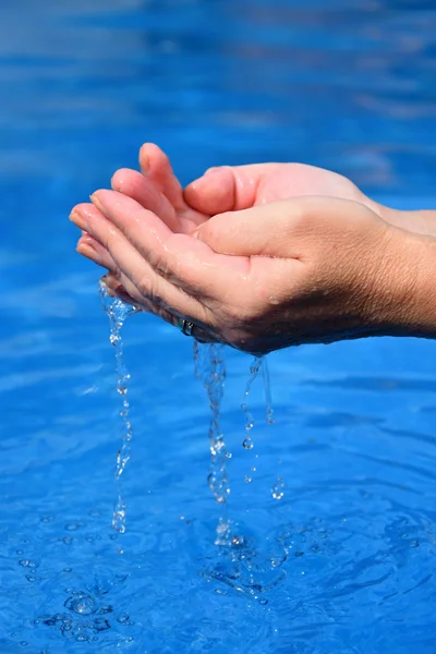 파란색 배경에 맑은 물과 인간의 손 — 스톡 사진