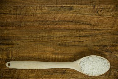 Pirinç ve tahta kaşık tablonun altındaki