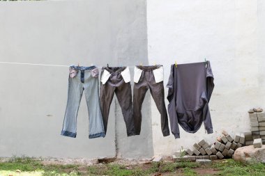 Dışarıdaki çamaşır ipinde asılı giysiler güneşte kuruyor.