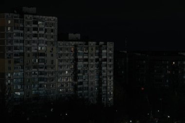 Uzun apartmanlar geceleri karanlıkta duruyor ve sadece birkaç aydınlatma penceresi doluymuş gibi görünüyor. Olay yeri kasvetli, muhtemelen bilinç kaybından etkilenmiş şehir atmosferini aktarıyor.