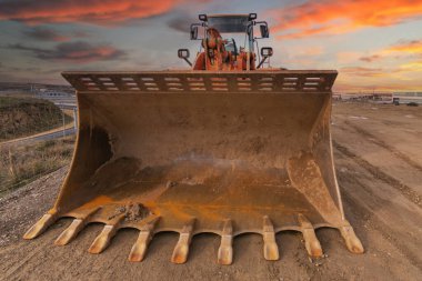 Kazıcı inşaat alanında bir yol inşa ediyor.
