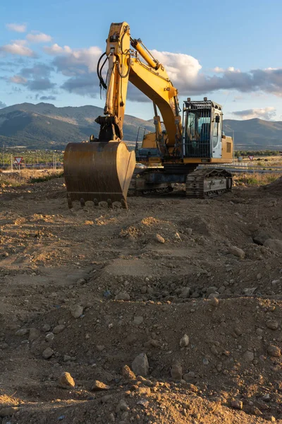 Excavator moving dirt and sand at a construction site