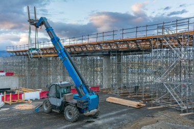 Üstgeçit inşaatında forkliftler.