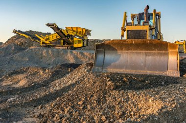 Taşı ve kayayı un ufak etmek ve çakıl üretmek için mekanik taşıma bandı ve kazıcı.