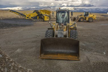 Güzel bir gün batımında bir şantiyede kazıcı.