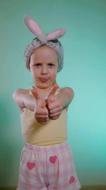 Dikey. Pijamalı küçük kız kendinden emin bir şekilde onaylıyor. Her şey yolunda. Çocuk dilini dışarı çıkarıyor ve parmağını kaldırıyor. Her şey yolunda..