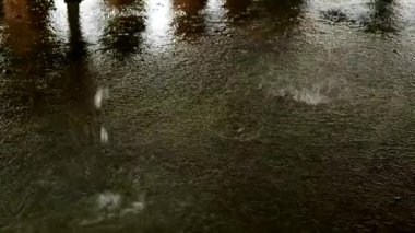 Su birikintisinde büyük yağmur damlaları. Ağır çekimde su sıçraması. Şiddetli yağmur inanılmaz damlalar ve bol miktarda su yaratır. Terli bir binada terlemek..