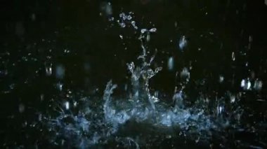 Büyük beyaz bir taş suya düşer. Yavaş çekim, bir sürü sıçrama ve su.