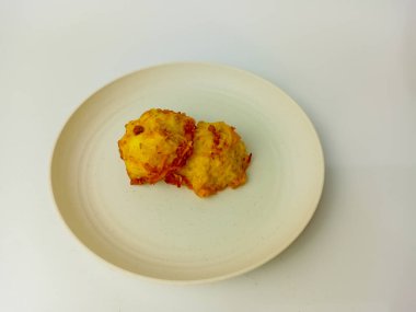 Tahu Fantasi or Tofu fantasy, a fried food made from tofu dough, noodles, and carrots. Served on a round plate, isolated on white background.