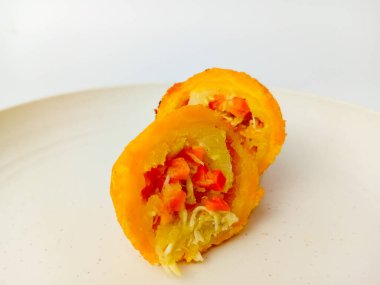 Kroket, kızarmış un, dolguyla karışık hamur, sonra ekmek kırıntılarıyla kaplanmış. İkiye bölünmüş, yuvarlak bir tabakta servis edilmiş, beyaz arka planda izole edilmiş..