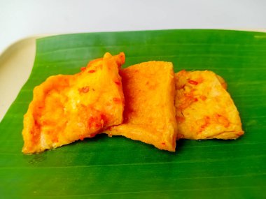 Tahu bumbu bali ya da bali baharatlı tofu, geleneksel Endonezya yemeği baharatlı soslu soya peyniri. Kare tabakta muz yaprağıyla servis edilir..