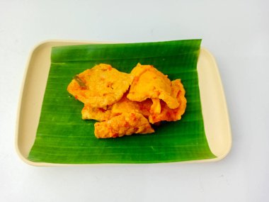 Tahu bumbu bali ya da bali baharatlı tofu, geleneksel Endonezya yemeği baharatlı soslu soya peyniri. Kare tabakta muz yaprağıyla servis edilir..