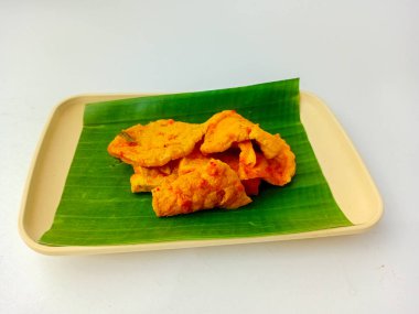 Tahu bumbu bali ya da bali baharatlı tofu, geleneksel Endonezya yemeği baharatlı soslu soya peyniri. Kare tabakta muz yaprağıyla servis edilir..