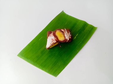 Dadar yuttu pisang coklat keju veya çikolatalı peynirli muzlu omlet ikiye bölündü ve muz yaprağında servis edildi, beyaz arka planda izole edildi..