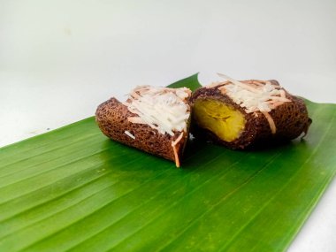 Dadar yuttu pisang coklat keju veya çikolatalı peynirli muzlu omlet ikiye bölündü ve muz yaprağında servis edildi, beyaz arka planda izole edildi..