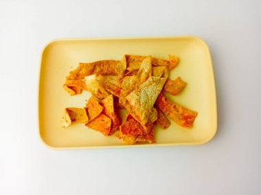 Kare tabakta servis edilen baharatlı atıştırmalıklar, beyaz arka planda izole edilmiş. Lezzetli yemek..