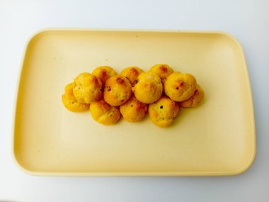 Kare tabakta yaban mersinli mini choux. Beyaz arka planda izole edilmiş. Lezzetli çerez.