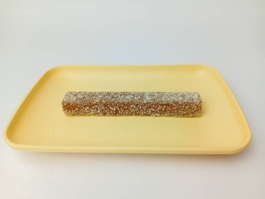 Kare tabakta hindistan cevizi taneleriyle kaplı, beyaz arka planda izole edilmiş tuzlu gofret..