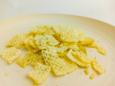 Yuvarlak tabakta gevrek yosun aromalı atıştırmalıklar, beyaz arka planda izole edilmiş..