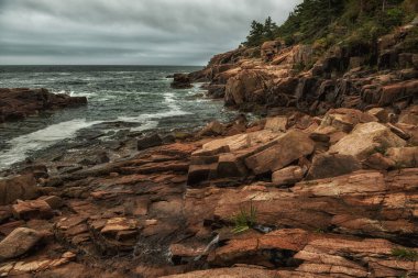 Atlantik Okyanusu 'nun kayalık kıyıları. Kasvetli hava. Acadia Ulusal Parkı. ABD. Maine. Dramatik deniz manzarası.