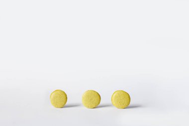 Beyaz arka planda sarı badem kurabiyeleri.