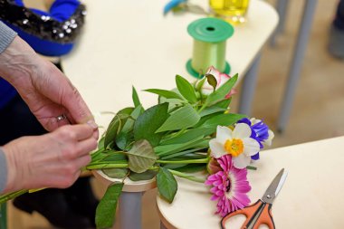 Buket süsleme dersi. Bir buket buketi kesen çocuk elleri. Anneler Günü 'nde ya da 8 Mart' ta anneme hediye hazırlıyorum..