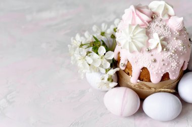 Paskalya 'da hayat. Fırınlanmış Paskalya kekleri ve kiraz çiçekli renkli yumurtalar. yumuşak pastel renkler.