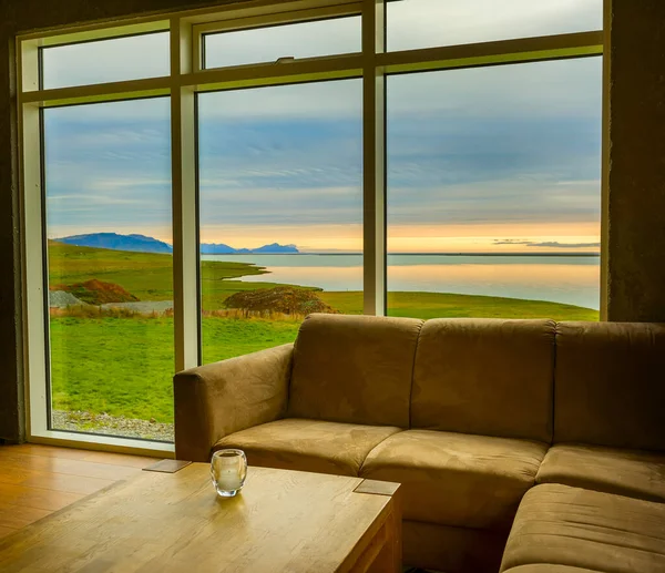 Room in a Scandinavian style and a view from the panoramic window on a beautiful natural landscape. Iceland.