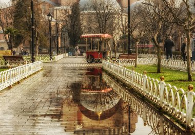 Yağmurdan sonra İstanbul 'un merkez meydanı. Cami kaldırımdaki suya yansıdı. Seçici odaklanma sadece ön planda. İstanbul. Türkiye.