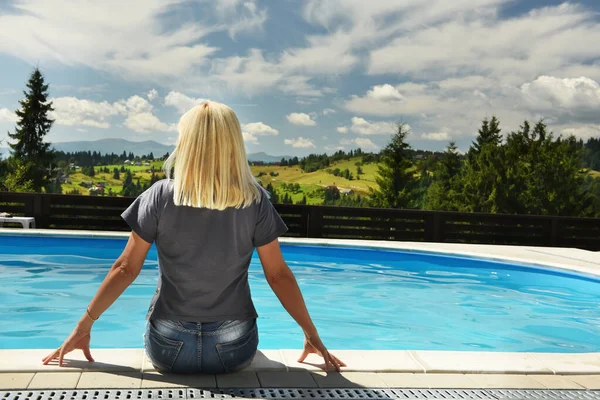 Uma Menina Sentada Junto Piscina Com Costas Com Vista Para — Fotografia de Stock