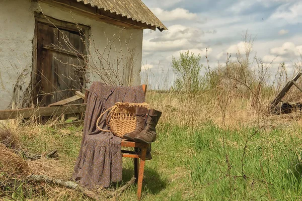 ヴィンテージレトロなヒップスター写真 ヴィンテージアイテム 国の庭の古い椅子の上のドレス バッグ ブーツ — ストック写真