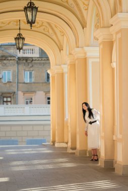 Mimari kemerlerin arasında şirin elbiseli bir kız. Odessa 'da. Ukrayna. Opera ve Bale Tiyatrosu.