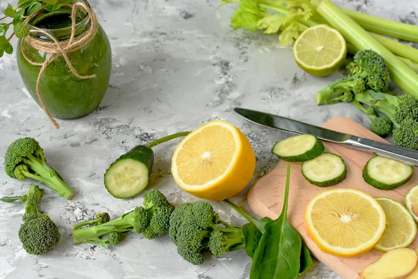 Brokoli, salatalık, limon, zencefil sağlıklı bir meyve suyu için yeşil sebze. Gri beton arka planda farklı sebzeler ve yeşil smoothie..